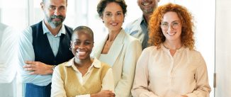 Business team standing together looking at camera and smiling in modern office. Modern multi ethnic team, creative occupation. Coworker teamwork concept.