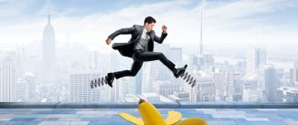 A businessman uses springs that are attached to his shoes to avoid landing on a banana peel