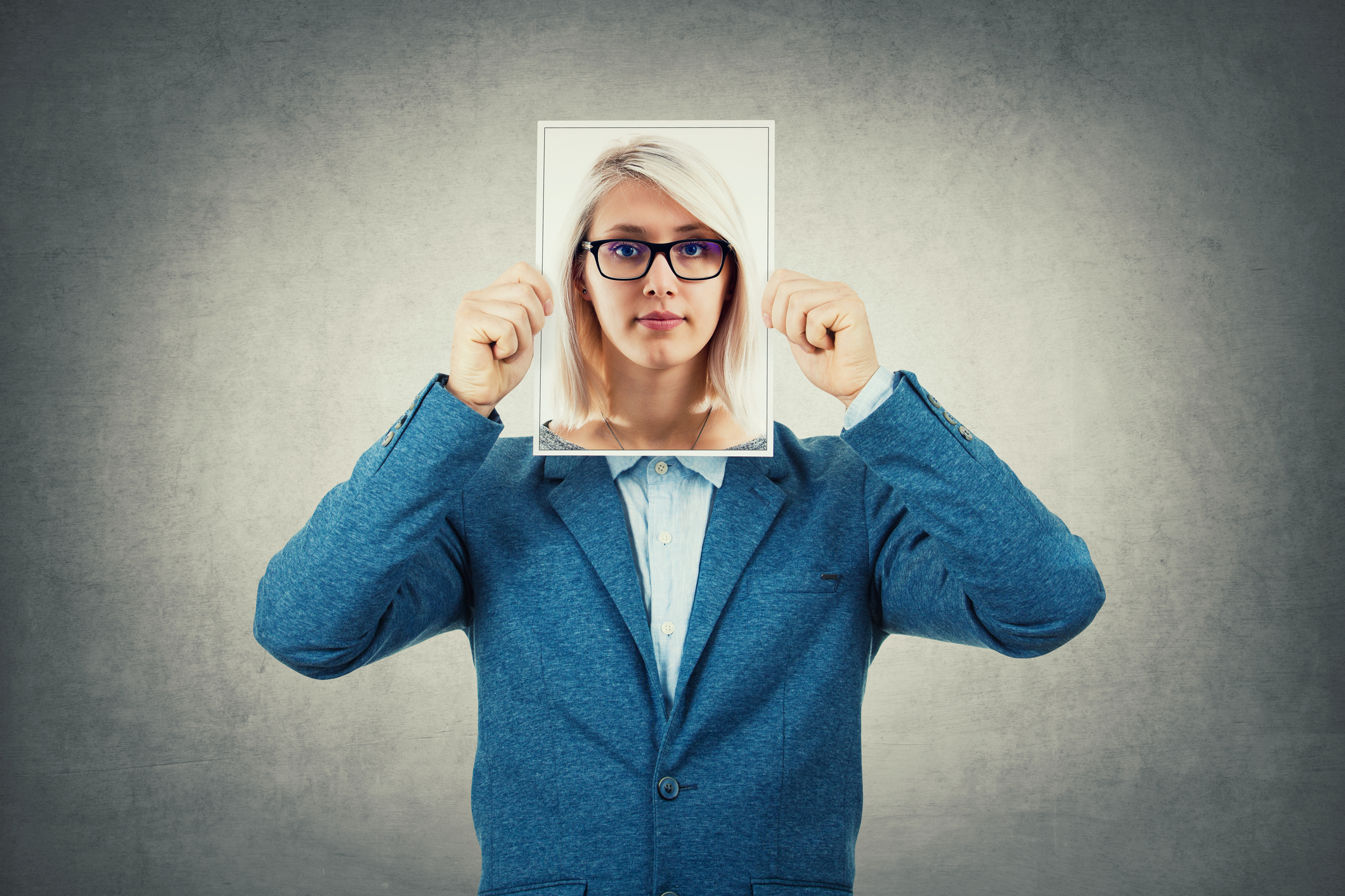 Businessman use a woman portrait as undercover, hiding his face behind photo sheet, like a fake mask. Private life, split personality and unreal identity concept.